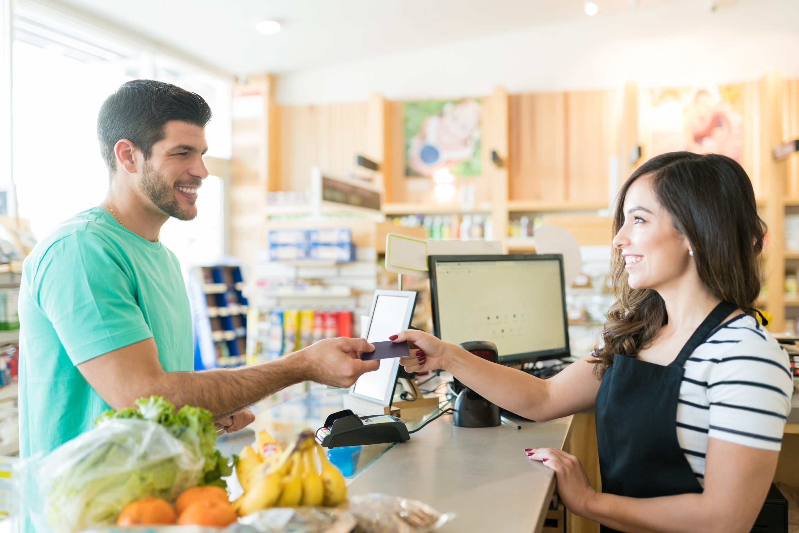 Os Seis C´s para 2022 1 caixa feminina sorridente com comprador no balcao de check out na mercearia scaled